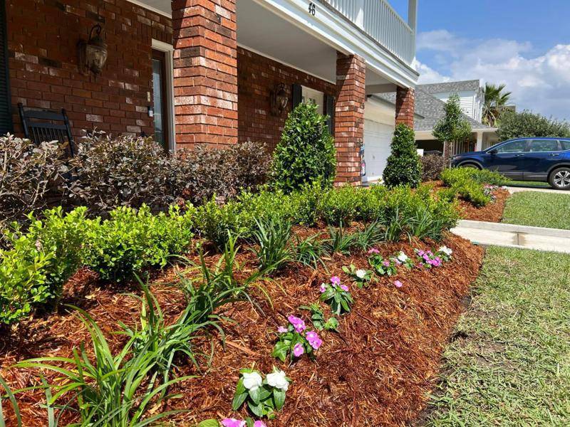 Lush garden bed with vibrant flowering plants and neatly trimmed shrubbery, meticulously maintained by Southern Grounds LLC in Marrero, LA.